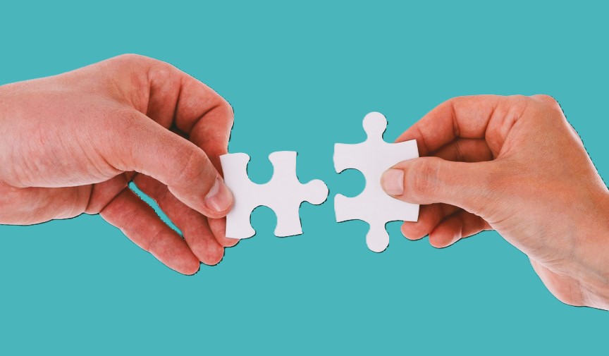 2 Hände mit Puzzlesteinen. Sprache als verbindenes element bei KI und Beziehungen