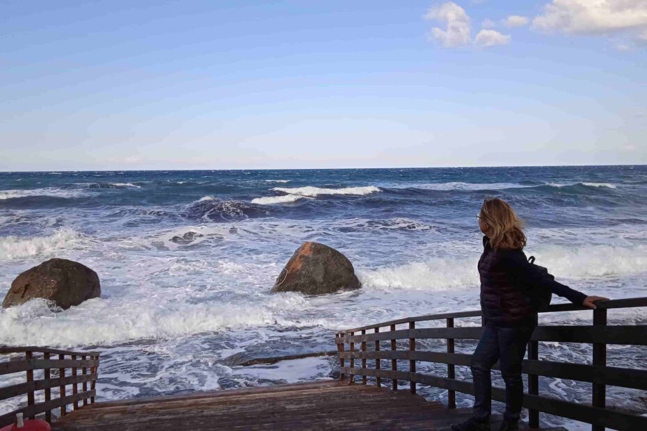 Frau am stürmischen Strand überlegend. Neustart50