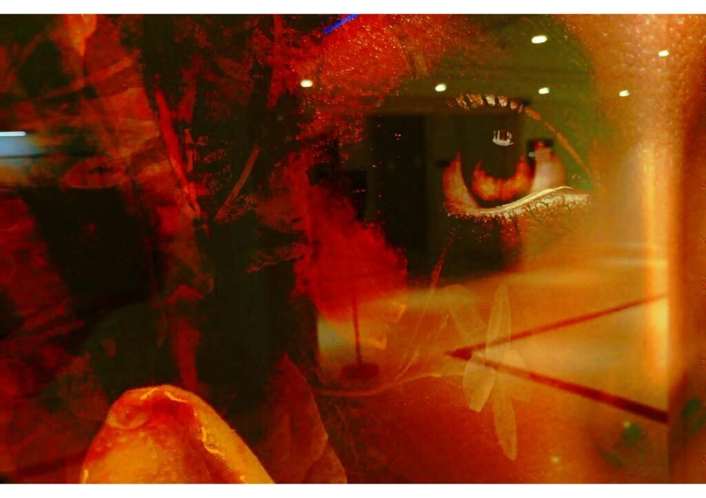 Fotokunst mit einem einzelnen Auge in intensiven Rot- und Goldtönen